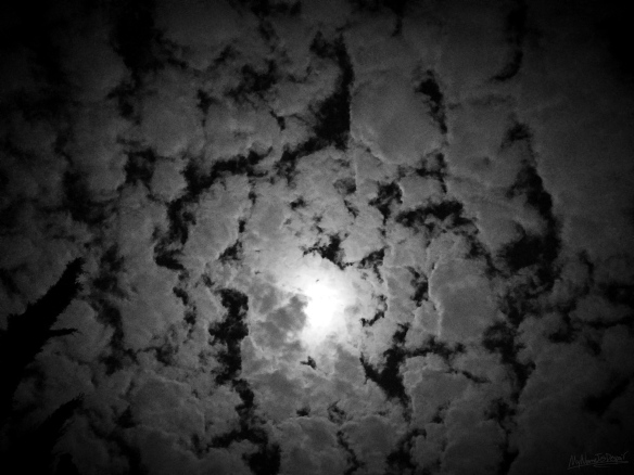 Moonlight shining through a cloudy night sky.